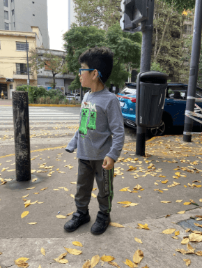 Niño parado solo en la vereda, esperando.